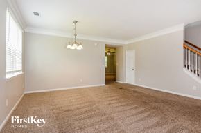 Dallas house for rent - an empty living room with carpet and a staircase
