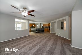 Summerville house for rent - A spacious living room with a fan and carpeted floor.