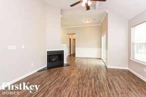 Summerville house for rent - A spacious room with a fireplace and wooden flooring.