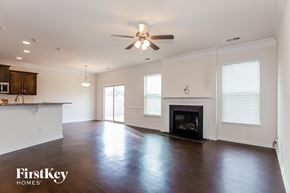 Mooresville house for rent - an empty living room with a fireplace and a ceiling fan