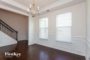 Mooresville house for rent - a dining room with white walls and windows and a chandelier