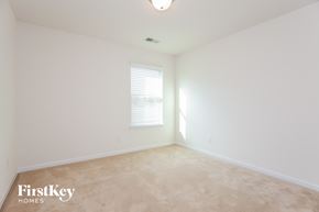 Mooresville house for rent - a bedroom with white walls and carpet and a window