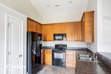 Mount Holly house for rent - a kitchen with wooden cabinets and black appliances