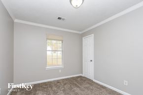 Hampton house for rent - a bedroom with carpet and a white door and window
