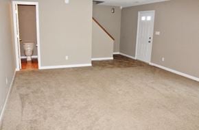 Mooresville house for rent - an empty living room with a carpeted floor and a toilet