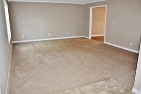 Mooresville house for rent - an empty living room with carpet and a door