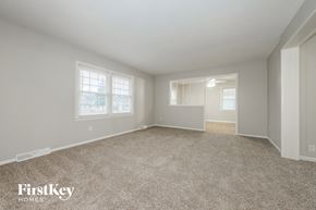 Belton house for rent - A spacious empty room with carpet flooring and two windows.