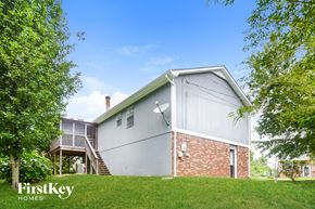 Trussville house for rent - a white and brick house on a hill with trees