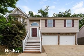 Dallas house for rent - A two-story house with a red door and white garage doors.
