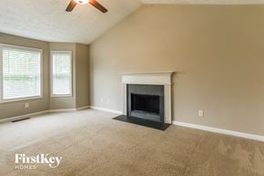 Dallas house for rent - A room with a fireplace and a ceiling fan.