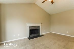 Dallas house for rent - A living room with a fireplace and a fan on the ceiling.