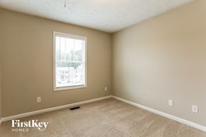 Dallas house for rent - A room with a carpet floor and a window showing a view of a building outside.