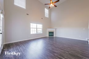 Mcdonough house for rent - A spacious room with a fireplace and a ceiling fan.