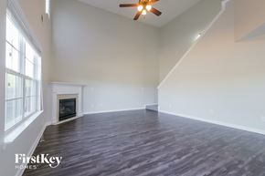 Mcdonough house for rent - A spacious room with a fireplace and wood flooring.
