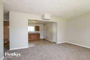 Saint Charles house for rent - A carpeted room with a kitchen in the background.