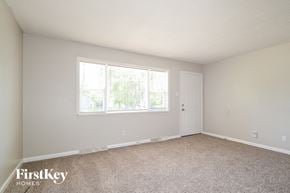 Saint Charles house for rent - A room with a carpeted floor and a window with a view of trees.