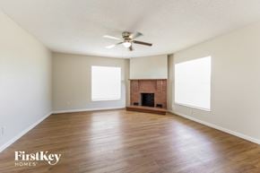 Port Charlotte house for rent - an empty living room with wood floors and a fireplace