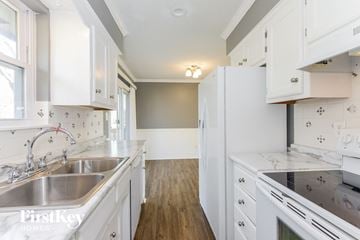 Belton house for rent - a kitchen with white cabinets and white counter tops and a sink