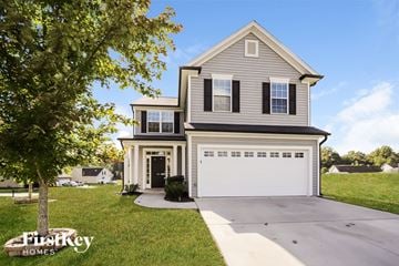 Winston-Salem house for rent - a gray house with a white garage door and a tree