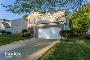 Mooresville house for rent - a house with a white garage door in front of a lawn