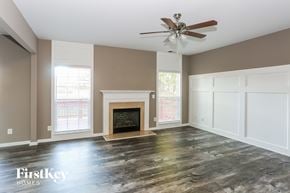 Mooresville house for rent - a living room with a fireplace and a ceiling fan
