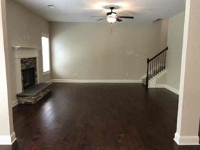 Newnan house for rent - a empty living room with a ceiling fan and a fireplace