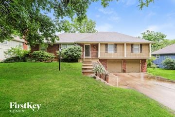 Raymore house for rent - a small brick house with a yard and a driveway