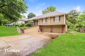 Raymore house for rent - a house with a driveway and a garage door