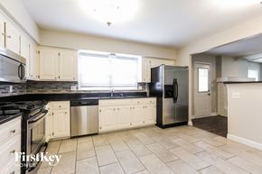 Raymore house for rent - a kitchen with white cabinets and a stainless steel refrigerator