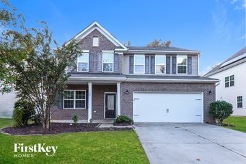 Mooresville house for rent - A house with a garage and a tree in front of it.