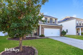 Mooresville house for rent - A tree in front of a house with the words "FirstKey Homes" on the bottom left.