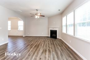 Mooresville house for rent - A spacious room with wood flooring and a ceiling fan.