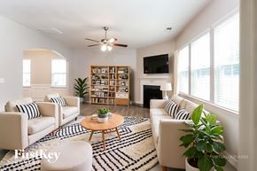 Mooresville house for rent - A living room with a white couch, a coffee table, and a ceiling fan.