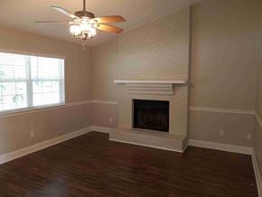 North Charleston house for rent - A room with a fireplace and a ceiling fan.
