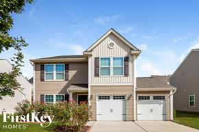 Mooresville house for rent - A two-story house with a garage is branded with the FirstKey Homes logo.