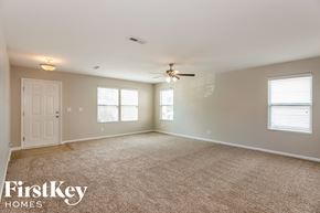 Mooresville house for rent - A spacious room with a carpeted floor and a ceiling fan.