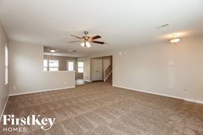 Mooresville house for rent - A spacious room with a carpeted floor and a ceiling fan.