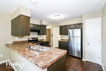 Cordova house for rent - a kitchen with granite counter tops and a stainless steel refrigerator