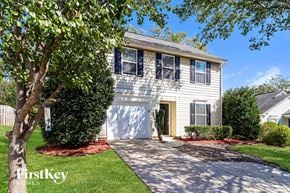 Mooresville house for rent - a white house with a white garage door and a tree