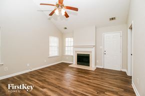 Covington house for rent - a living room with a fireplace and a ceiling fan