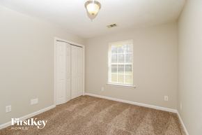 Covington house for rent - a bedroom with carpet and a door and a window