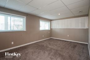 Florissant house for rent - A room with a carpeted floor and a wall of windows.