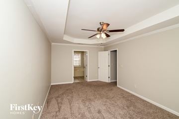 Helena house for rent - a living room with carpet and a ceiling fan