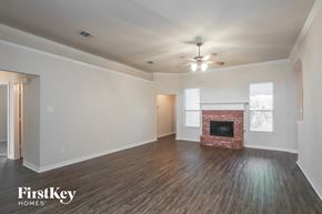 Forney house for rent - a living room with a fireplace and a ceiling fan