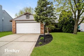 Greenwood house for rent - a white garage door on a brick house with a lawn and a lamp post
