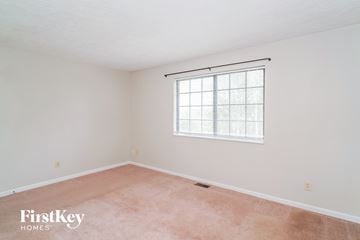 Greenwood house for rent - a bedroom with white walls and a window and pink carpet