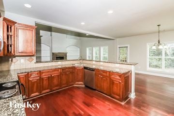 Mcdonough house for rent - a kitchen with wooden cabinets and granite counter tops