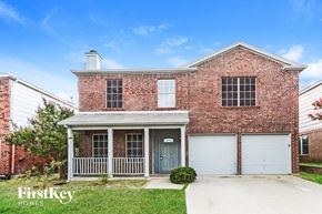 Arlington house for rent - A brick house with a blue door and garage doors.