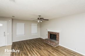 Arlington house for rent - A living room with a fireplace and a ceiling fan.