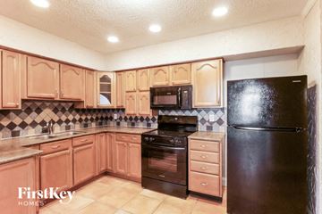 Hallandale Beach house for rent - A kitchen with wooden cabinets and black appliances.